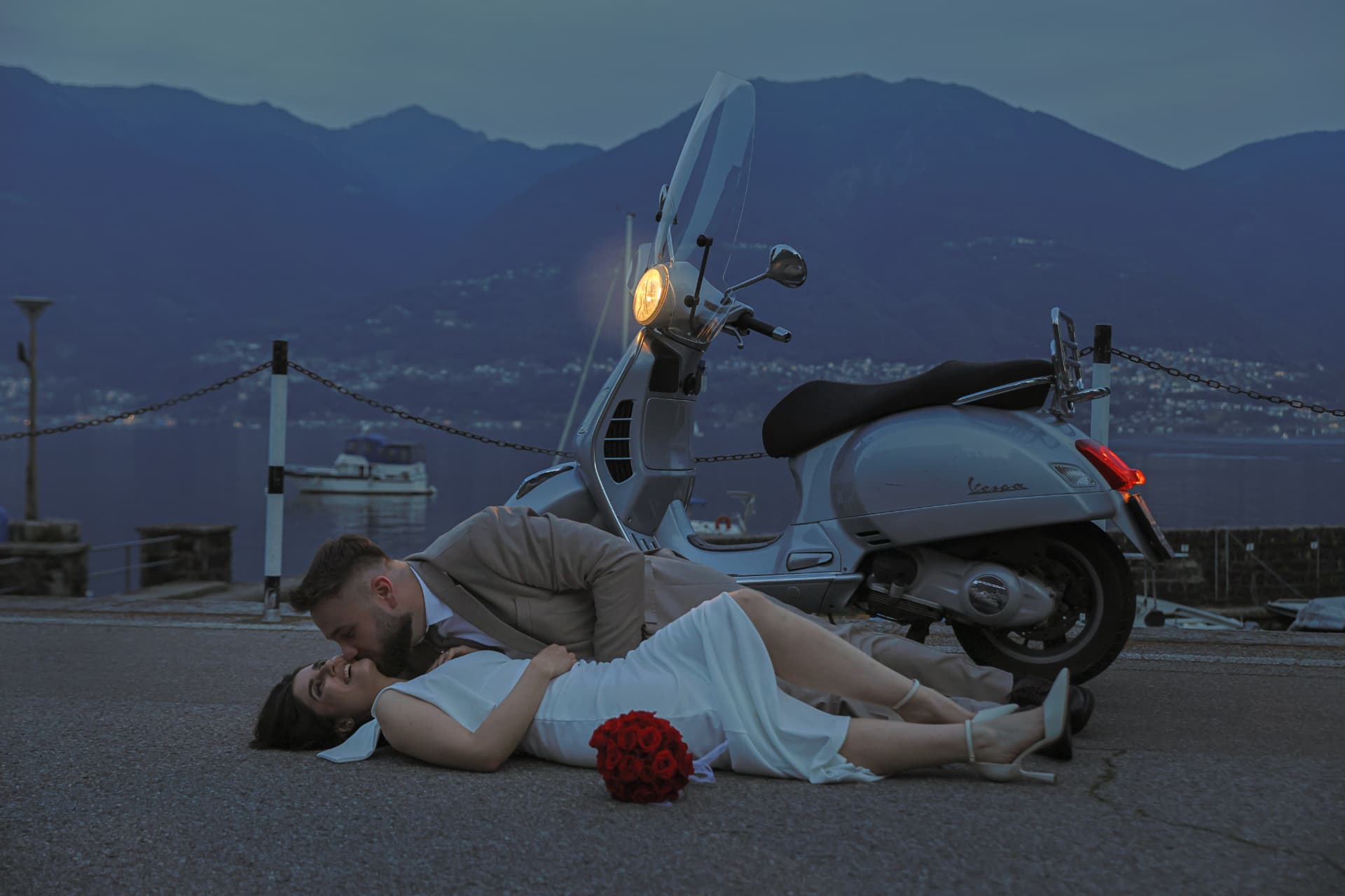 Newlyweds beside a Vespa at blue hour