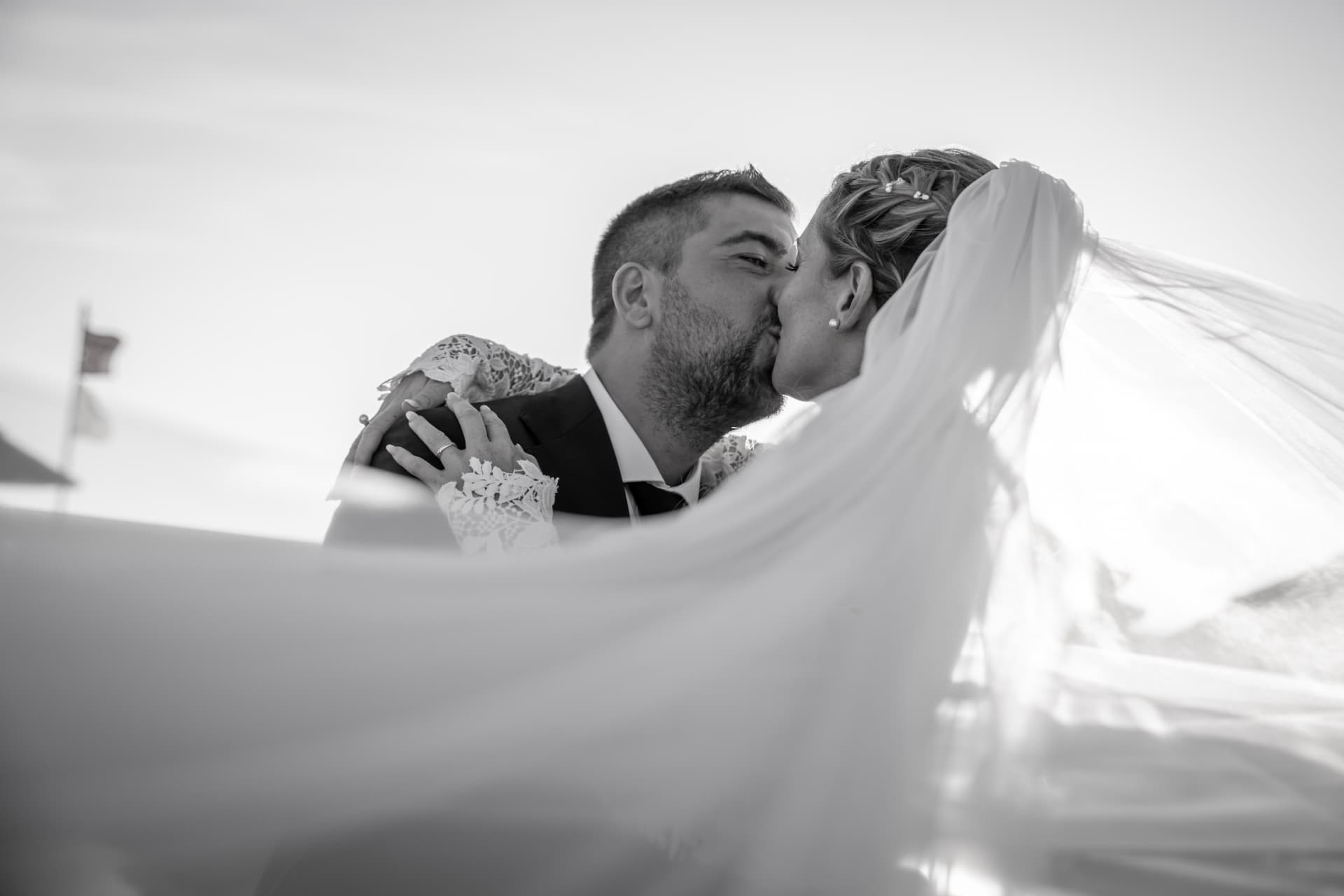 Black and white portrait of newlyweds beneath the veil